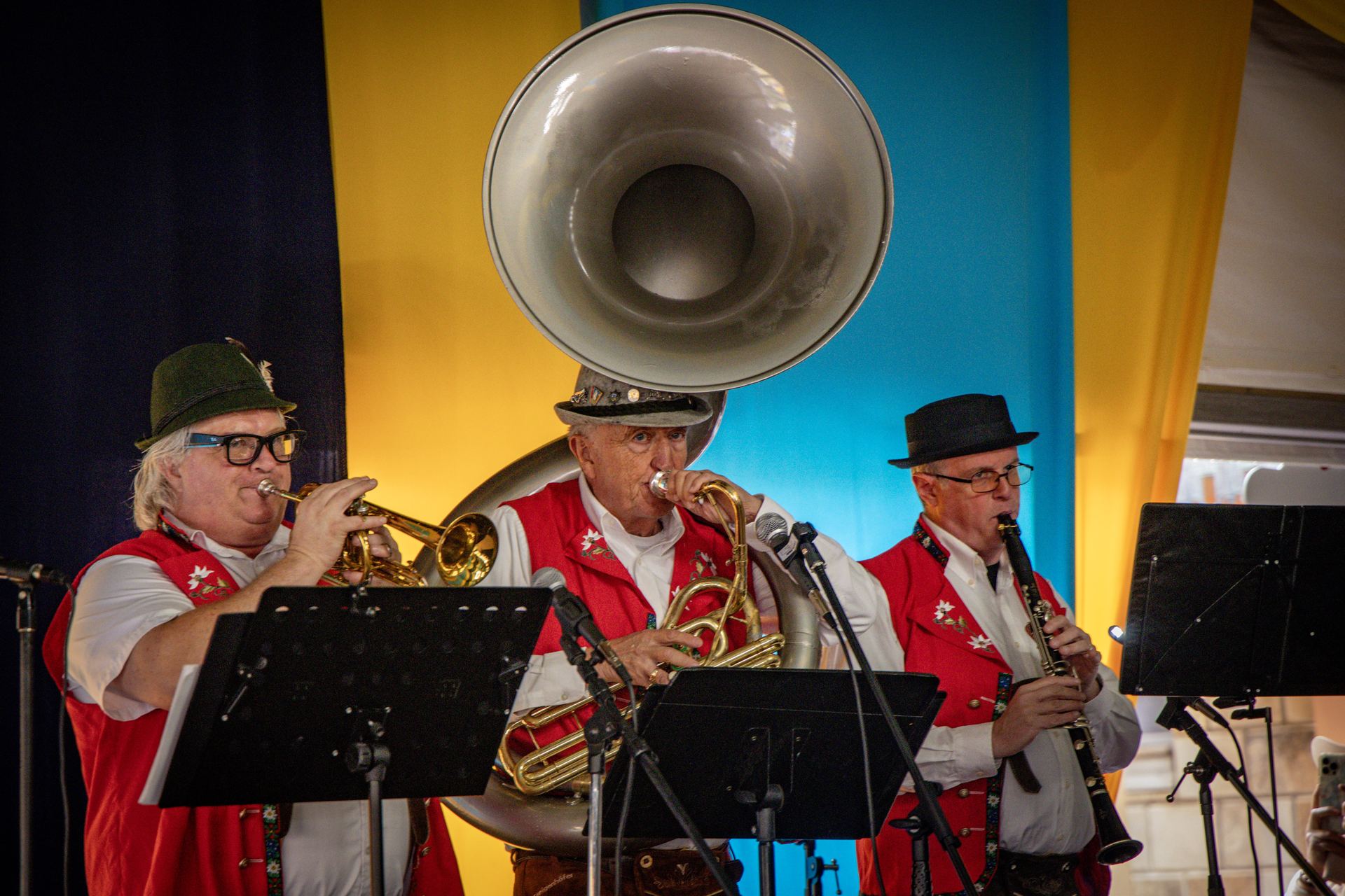 The live oompah band playing trumpet, tuba, and clarinet under the festival tent